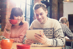 Couple using tablet computer in cafe